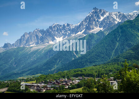 Französische Alpen, Les Houches Dorflandschaft mit Aiguille du Midi und Aiguilles de Chamonix dahinter, Chamonix Valley, Frankreich, Europa Stockfoto