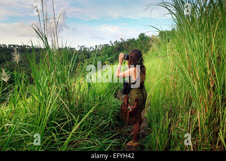 Junge Frau nehmen Foto von Blick auf Bunaken Island, Sulawesi Stockfoto