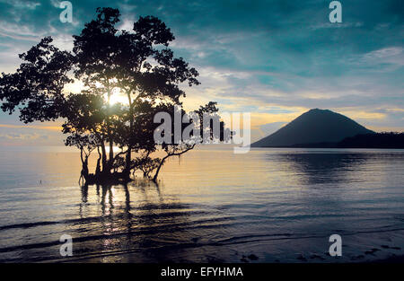 Sonnenuntergang an der Küste der Insel Bunaken mit Manado Tua Insel im Hintergrund Stockfoto
