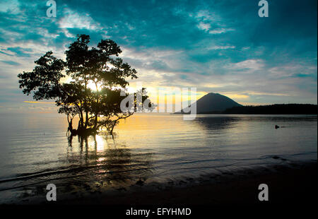 Sonnenuntergang an der Küste der Insel Bunaken mit Manado Tua Insel im Hintergrund Stockfoto