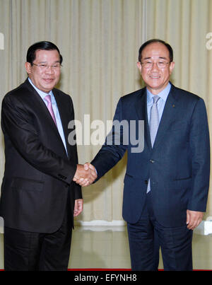 Phnom Penh, Kambodscha. 12. Februar 2015. Kambodschanische Premierminister Hun Sen (L) schüttelt Hände mit Lee Duk Hoon (R), Präsident der Export-Import Bank der Republik Korea in Phnom Penh, Kambodscha, 12. Februar 2015. Südkorea am Donnerstag unterzeichnet 56 Millionen US-Dollar für die Entwicklung einer 63 km lange Straße nach Kambodscha bieten nach einer Erklärung von der kambodschanischen Seite veröffentlicht. © Sovannara/Xinhua/Alamy Live-Nachrichten Stockfoto