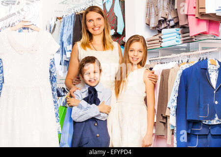 Lächelnde Frau mit jungen und Mädchen in der Nähe im shop Stockfoto