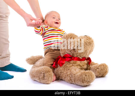 Baby Boy über Plüsch Hund auf weißem Hintergrund Stockfoto