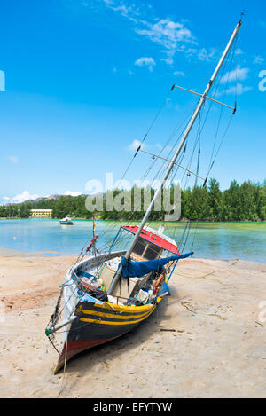 Altes Fischerboot am tropischen Strand von Praslin Insel Seychellen. Vertikale erschossen Stockfoto
