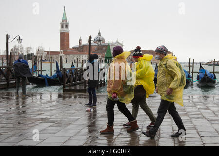 Als der jährliche Karneval feiern losgehen, in Venedig, Hochwasser (Acqua Alta) viele Teile der Stadt überflutet. Viele Touristen wurden von den hohen Wassergehalt ertappt und musste kaufen verstärkten Kunststoff Stiefel in leuchtenden Farben - die über normale Schuhe - getragen werden, trocken zu halten. Besseres Wetter für den Karneval in Markusplatz entfernt dieses Wochenende prognostiziert. Stockfoto