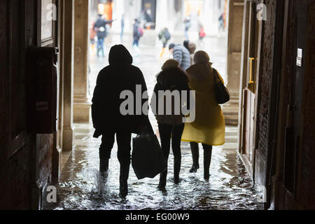 Als der jährliche Karneval feiern losgehen, in Venedig, Hochwasser (Acqua Alta) viele Teile der Stadt überflutet. Viele Touristen wurden von den hohen Wassergehalt ertappt und musste kaufen verstärkten Kunststoff Stiefel in leuchtenden Farben - die über normale Schuhe - getragen werden, trocken zu halten. Besseres Wetter für den Karneval in Markusplatz entfernt dieses Wochenende prognostiziert. Stockfoto