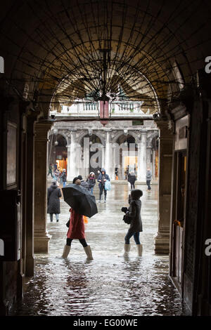 Als der jährliche Karneval feiern losgehen, in Venedig, Hochwasser (Acqua Alta) viele Teile der Stadt überflutet. Viele Touristen wurden von den hohen Wassergehalt ertappt und musste kaufen verstärkten Kunststoff Stiefel in leuchtenden Farben - die über normale Schuhe - getragen werden, trocken zu halten. Besseres Wetter für den Karneval in Markusplatz entfernt dieses Wochenende prognostiziert. Stockfoto