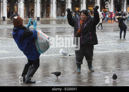 Als der jährliche Karneval feiern losgehen, in Venedig, Hochwasser (Acqua Alta) viele Teile der Stadt überflutet. Viele Touristen wurden von den hohen Wassergehalt ertappt und musste kaufen verstärkten Kunststoff Stiefel in leuchtenden Farben - die über normale Schuhe - getragen werden, trocken zu halten. Besseres Wetter für den Karneval in Markusplatz entfernt dieses Wochenende prognostiziert. Stockfoto