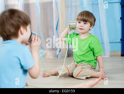 Kinder-Brüder im Gespräch mit Blechdose Telefon Stockfoto