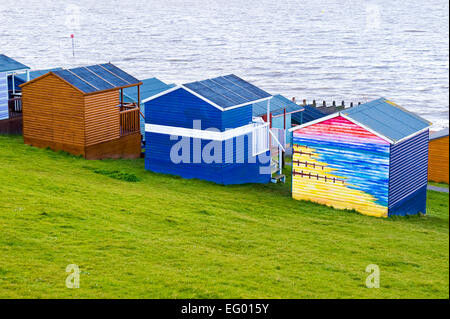 bunte hölzerne Strandhütten mit Blick auf das Meer bei Tankerton in der Nähe von Whitstable Kent Stockfoto