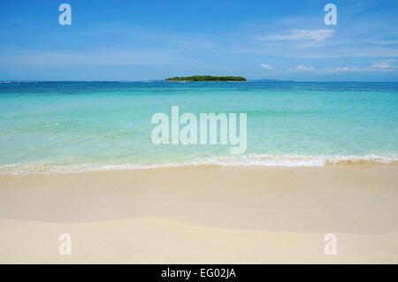 Sandstrand mit türkisfarbenem Wasser und einer tropischen Insel am Horizont, Cayos Zapatilla, Karibik, Bocas del Toro, Panama Stockfoto