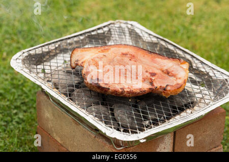 Ein Speck Steak gegrillt auf einem Einweg-Grill im freien Stockfoto