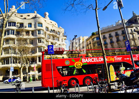 Barcelona City Tourbus in eine Front von Mila Haus auch bekannt als La Pedrera von Antoni Gaudi entworfen. Barcelona, Katalonien, Spanien. Stockfoto