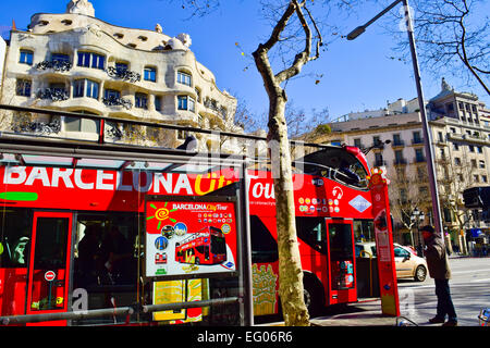 Barcelona City Tourbus in eine Front von Mila Haus auch bekannt als La Pedrera von Antoni Gaudi entworfen. Barcelona, Katalonien, Spanien. Stockfoto