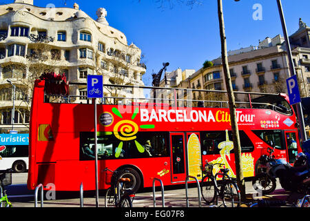 Barcelona City Tourbus in eine Front von Mila Haus auch bekannt als La Pedrera von Antoni Gaudi entworfen. Barcelona, Katalonien, Spanien. Stockfoto