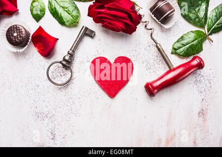 Herzen, rote Rosen, Schokolade, Schlüssel und Korkenzieher auf weißem Holz, Liebe Hintergrund, Ansicht von oben Platz für text Stockfoto