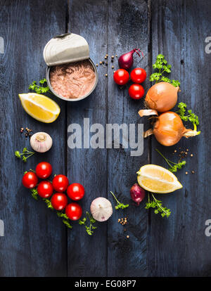 Tomatensauce mit Thunfisch Zutat mit Kräuter, Gewürze und Zitrone auf blauen hölzernen Hintergrund, Rahmen, Ansicht von oben Stockfoto