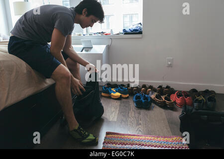 Junge Hispanic / Latino Mann in seinem Schlafzimmer Vorbereitung ins Fitness-Studio in New York City Stockfoto