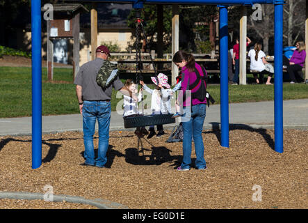 Eltern, junge Mädchen, Kinder, auf Schaukel, Spielplatz, Pioneer Park, Stadt, Novato, Kalifornien, Vereinigte Staaten von Amerika Stockfoto