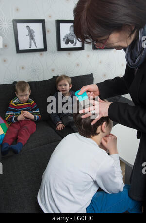 Mutter Überprüfung Childs Haar für Läuse Stockfoto