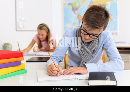 Foto von zwei Studenten in ihrer Klasse in ihre Hefte schreiben. Stockfoto