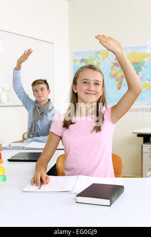 Foto von zwei Studenten in ihrer Klasse Erziehung ihrer Hände eine Frage beantworten. Stockfoto