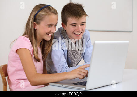 Zwei Schüler ihre Hausaufgaben mit einem Laptop. Stockfoto