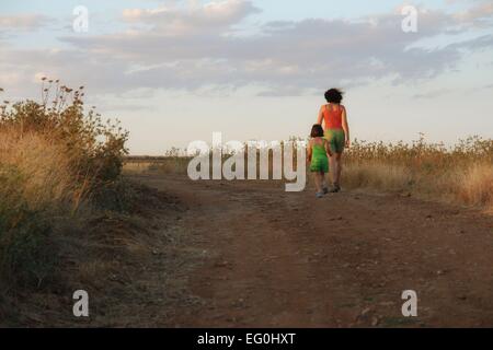 Mutter und Tochter gehen in Wiese Stockfoto