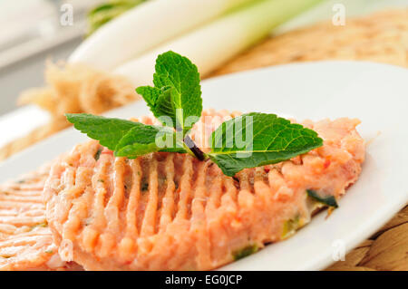 Nahaufnahme von einige rohe Burger mit Hühnerfleisch und Gemüse in einer Platte auf dem Küchentisch Stockfoto