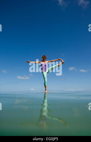 Frau, die eine ausgedehnte Hand-zu-Big-Toe-Pose am Strand, Oahu, Hawaii, USA macht Stockfoto