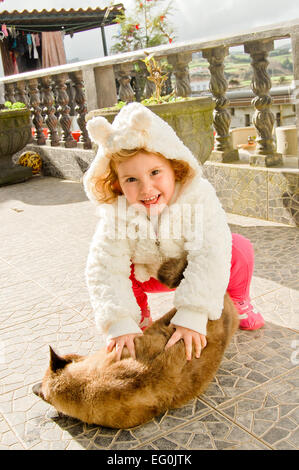 Mädchen spielen mit Ingwer Katze auf Terrasse Stockfoto