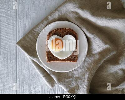 Scheibe Toast mit Herz geformt Spiegelei Stockfoto
