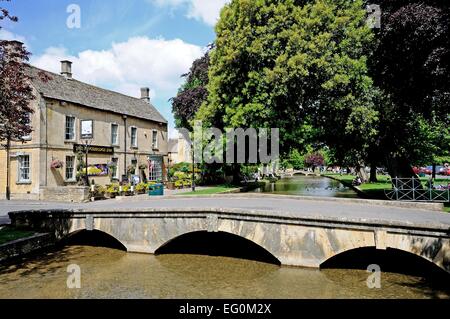 Stein-Fußgängerbrücke über den Fluss Windrush Kingsbridge Inn nach hinten, Bourton auf dem Wasser, Gloucestershire, England, Stockfoto