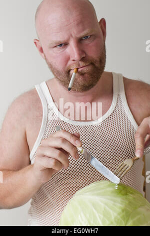 Weird Mann essen Kohl und Pilze beim Rauchen einer Zigarette. Stockfoto