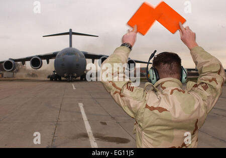 Ein US-Air Force Crewchief führt eine Luftwaffe c-17 Globemaster III-Frachtflugzeug mit US-Verteidigungsminister Donald H. Rumsfeld auf 16. Dezember 2001, am Camp Hochburg Freiheit in Usbekistan. Rumsfeld war es, Truppen zur Unterstützung der Operation Enduring Freedom zu besuchen.  Staff Sgt Steven Pearsall Stockfoto
