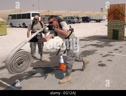 US Air Force Oberstleutnant Joel Gartner, 379th Expeditionary Logistik Bereitschaft Staffelkapitän, konkurriert in der Schlauch werfen Veranstaltung während einer Feuer-Muster Wettbewerb, 11. Oktober 2009, im Südwesten Asien. Das 379th Bauingenieur-Geschwader, das Feuerwehr Feuer Sicherheitswoche hier mit einem Muster kam zu dem Schluss, die mehrere Ereignisse und Übungen Feuerwehr simuliert, führen in regelmäßigen Abständen.  Staff Sgt Robert Barne Stockfoto