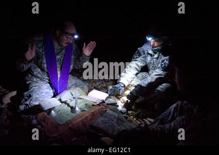 US Army Chaplain Captain Carl Subler, 5. Stryker Brigade Combat Team, 2. US-Infanteriedivision, liefert eine katholische Messe an Soldaten vom 4. Bataillon, 23. Infanterie-Regiment Transport an den Hubschrauber Ladezone auf Forward Operating Base Wolverine, Zabul Provinz, Afghanistan, 12. Dezember 2009 erwartet.  Staff Sgt Christine Jones Stockfoto