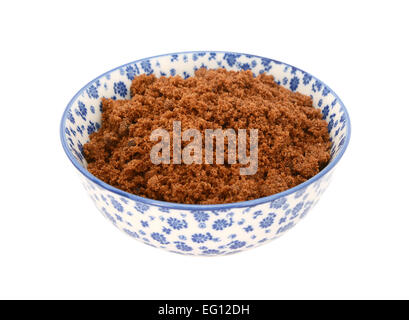 Dunkel braun weich / Muscovado Zucker in einer blau-weißen Porzellanschüssel mit floralem Design, isoliert auf weißem Hintergrund Stockfoto