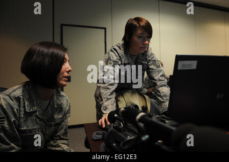 Technische Sgt. Adrienne Brammer und Giovanna Squadrito, 1st Combat Kamera Squadron, spricht über ihre video-Dokumentation der c-17 Flugzeuge von Charleston Air Force Base, S.C., am 16. Dezember 2009.  Die c-17 Flugzeuge führte eine strategische Brigade Airdrop Übung über Norden Hilfs Flugplatz in der Nähe von Northern, S.C., 16. Dezember 2009, demonstrieren die globale Projektion des US-Airpower. In der Luft Soldaten vom 2-319th Airborne Field Artillery, 82. US-Luftlandedivision, Fort Bragg, N.C., waren Luft sank in der Übung zusammen mit Cargo-Paletten zu simulieren, die Beschlagnahme von einem entfernten Flugplatz, vorausgesetzt Stockfoto