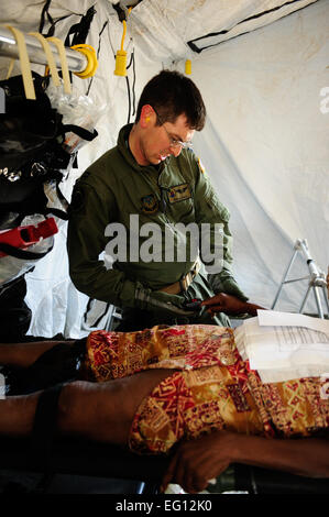 US Air Force Captain Rob Clontz, 1st Special Operations Support Squadron fühlt den Puls der verletzte Haitianer in einer Unfall-Sammelstelle am Flughafen von Port-Au-Prince 15. Januar 2010.  US-Verteidigungsministerium Vermögenswerte haben geschickt worden, nach Haiti humanitäre Hilfe und Katastrophenschutz bei, nachdem eine Erdbeben der Stärke 7 das Land am 12. Januar 2010 getroffen.  U.S. Air Force Photo von techn. Sgt. James L. Harper Jr., US Air Force. Veröffentlicht Stockfoto