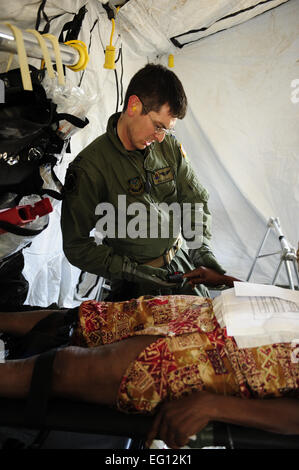 US Air Force Captain Rob Clontz, 1st Special Operations Support Squadron fühlt den Puls der verletzte Haitianer in einer Unfall-Sammelstelle am Flughafen von Port-Au-Prince 15. Januar 2010.  US-Verteidigungsministerium Vermögenswerte haben geschickt worden, nach Haiti humanitäre Hilfe und Katastrophenschutz bei, nachdem eine Erdbeben der Stärke 7 das Land am 12. Januar 2010 getroffen.  U.S. Air Force Photo von techn. Sgt. James L. Harper Jr., US Air Force. Veröffentlicht Stockfoto