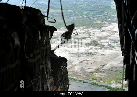 100118-F-2034C-081-Paletten Hilfsgüter Ausgang einer c-17 Globemaster III über Haiti 18. Januar 2010. Die c-17 mit Crew vom Flieger aus der 437 Airlift Wing, Charleston Air Force Base, Charleston, South Carolina, verstorbenen Papst AFB, North Carolina und 40 Paletten von Nahrung und Wasser geliefert.  Zur Gewährleistung der Sicherheit des haitianischen Volkes gesichert Joint Task Force-Haiti Bereich, in dem die Lieferungen airdrop. Einmal auf dem Boden wurden Lieferungen von JTF-Haiti, USAID und anderen humanitären Personals verteilt. Master Sergeant Shane A. Cuomo Stockfoto