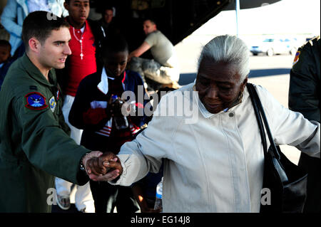 Kapitän Philip Noland, 317th Operations Support Squadron, hilft eine ältere Erdbeben Überlebende aus Haiti die Rampe von einem US-c-130, Homestead, Florida, 20. Januar 2010 herunter. Am 12. Januar erschütterte ein schweres Erdbeben das Land Haiti verlassen ca. 1,5 Millionen Menschen ohne Zuhause. Seitdem hat Homestead ARB schnell ein bedeutender Knotenpunkt für evakuierten Hilfe benötigen werden.  Personal-Sergeant Greg C. Biondo Stockfoto