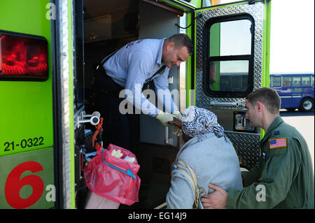 Kapitän Philip Noland, 317th Operations Support Squadron, und ein Dade County Feuer und Rettung Mitglied helfen eine Erdbeben Überlebende aus Haiti auf einen Krankenwagen, Homestead, Florida, 20. Januar 2010. Am 12. Januar erschütterte ein schweres Erdbeben das Land Haiti verlassen ca. 1,5 Millionen Menschen ohne Zuhause. Seitdem hat Homestead ARB schnell ein bedeutender Knotenpunkt für evakuierten Hilfe benötigen werden. Personal-Sergeant Greg C. BiondoReleased Stockfoto