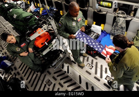 Kapitäne Roderick Reid, Center und Carol Nicholson, Flug Krankenschwestern aus dem 775. Expeditionary Aeromedical Evakuierung Flug, Falten eine amerikanische Flagge auf einem Flugzeug C-17A Globemaster III Sonntag, 20. Juni 2010 am Naval Air Station North Island, Kalifornien, wie Staff Sgt Brittany Zavala, ein 775. EAES aeromedical Evakuierung Techniker Uhren, während der wöchentlichen integrierte Continental United States Medical Operationsplan Mission oder ICMOP Mission als es unter der Abkürzung bekannt ist. Capt Nicholson, eine doppelte qualifizierte Flug-Krankenschwester für die kanadischen und US-amerikanischen Luftstreitkräfte, die Teilnahme an einem Austauschprogramm, sagt die Stockfoto