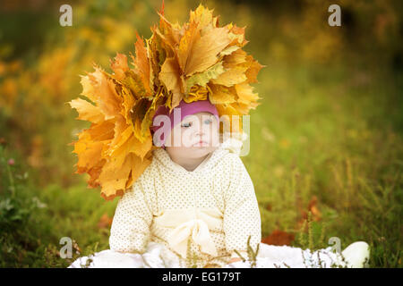 Mädchen mit Down-Syndrom trug einen Kranz von Federblättern Stockfoto