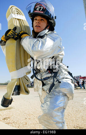 Airman 1st Class Kiounte Lineberger mit der 902nd Bauingenieur-Abteilung Feuerwehr hebt ein Schlauch-Bündel zu Beginn des Feuerwehr-Relais während der Schlacht um die Abzeichen Randolph Air Force Base, Texas, 4. Dezember 2010. Die Schlacht der Badges können Feuerwehrleute und Sicherheitskräfte Mitglieder Aspekte der jeweils anderen Jobs beim Bau Kameradschaft erleben.  Steve Thurow Stockfoto