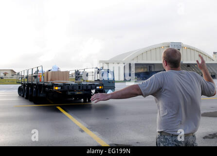 Ein US Air Force Flieger aus der 36. Airlift Squadron aus Yokota Air Base, Japan, lädt Boxen der humanitären Helfer waren auf eine c-130 Hercules Flugzeuge vor dem Abflug von Andersen Air Force Base, Guam, 14. Dezember 2010. In diesem Jahr werden mehr als 60 Boxen, einem Gewicht von mehr als 20.000 Pfund insgesamt 55 Inseln gelöscht. Betrieb Weihnachten Drop ist die Air Force am längsten laufende humanitäre Kampagne, die im Jahre 1952 begann. Flieger heute setzen die Tradition fort, die Versorgung zu abgelegenen Inseln des Commonwealth der nördlichen Marianen, Yap, Palau, Chuuk und Pohnpe Stockfoto