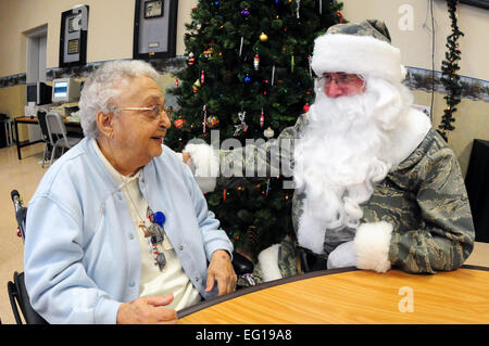 Chief Master Sgt. Paul Tangen des 119. Flügels, Dons eine speziell angefertigte Tarnung Santa entsprechen, wie er begrüßt Bewohner 15. Dezember 2010, während der jährlichen North Dakota National Guard Weihnachtsfeier in der North Dakota Veteranen nach Hause in Lissabon, N.D. North Dakota Air und Army National Guard Mitglieder Spenden persönliche Geld für Geschenke und präsentieren ihnen den Veteranen im Pflegeheim jedes Jahr während der Ferienzeit. DoD-Foto von Senior Master Sergeant David H. Lipp Stockfoto