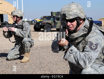 US Air Force Tech Sgts. Scott Tracy vorne und Robert Henry zurück, sowohl aus der 944th Sicherheit Kräfte Squadron, Ziel ist m-4 Gewehre gleichzeitig die Fähigkeit zu überleben und betreiben Bereich 8. Januar 2011, während der Ausbildung Montage.  Staff Sgt Louis Vega Jr. Stockfoto